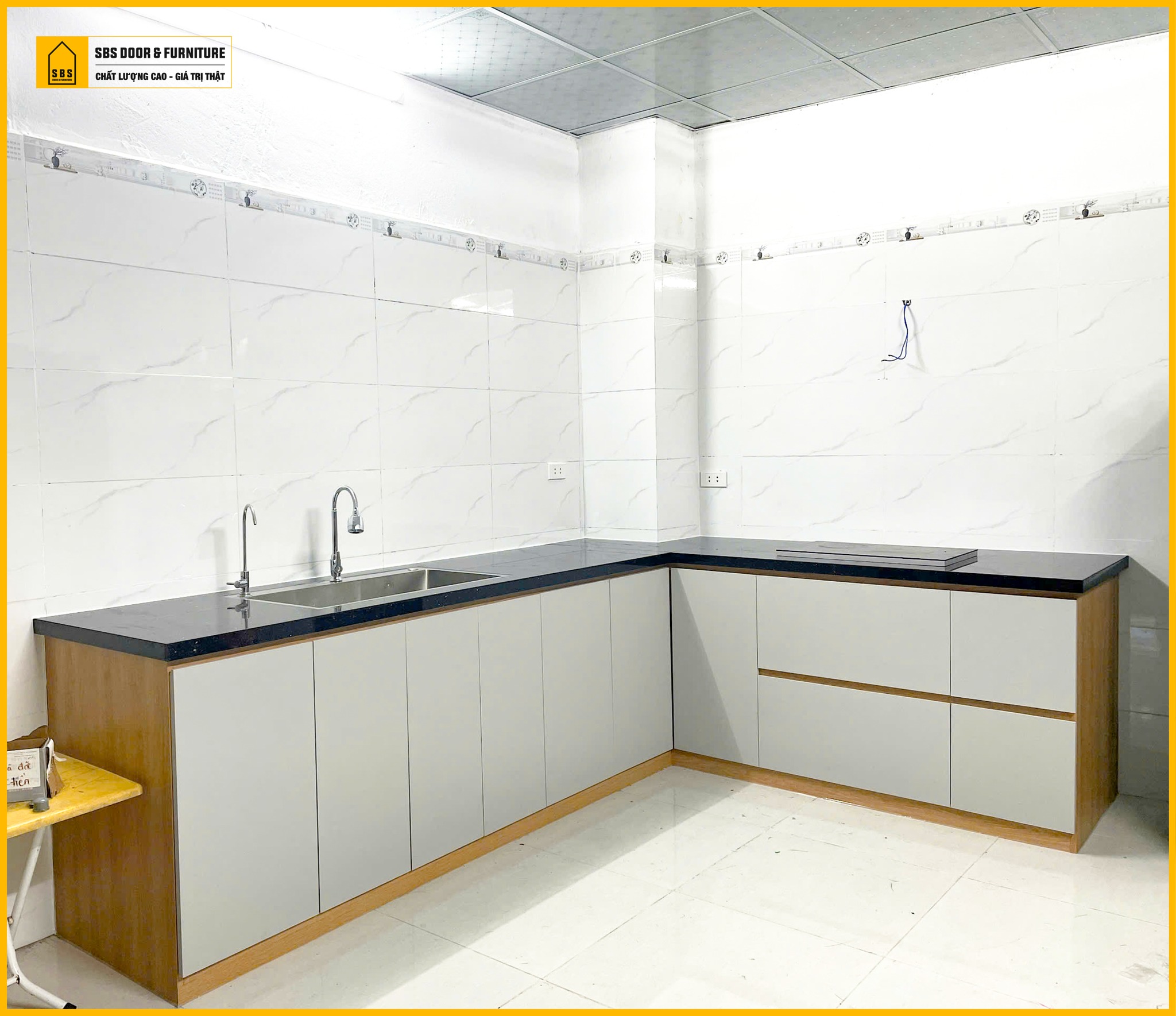 Không gian bếp gia đình trẻ với tủ bếp nhựa màu xám Harmony chống ẩm mốc.